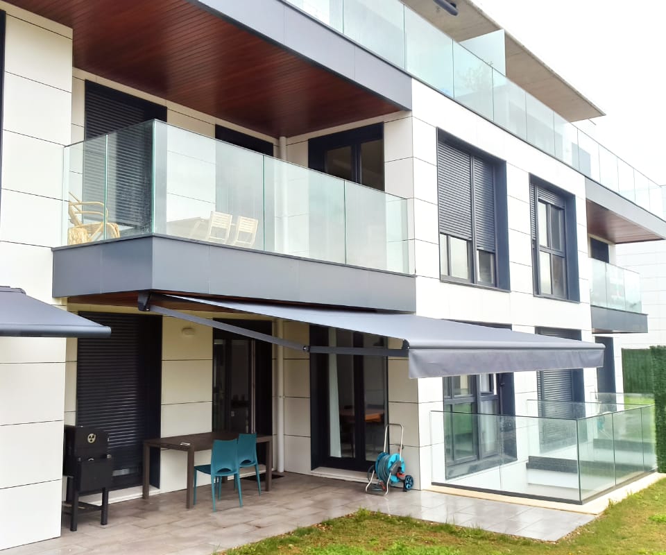 Etxebizitza moderno baten terraza batean instalatutako toldo hedagarri grisa, Itzalki Toldoak enpresak Zarautzen (Gipuzkoa, Euskal Herria) jarritakoa, Azpeitian ere jarduten duena