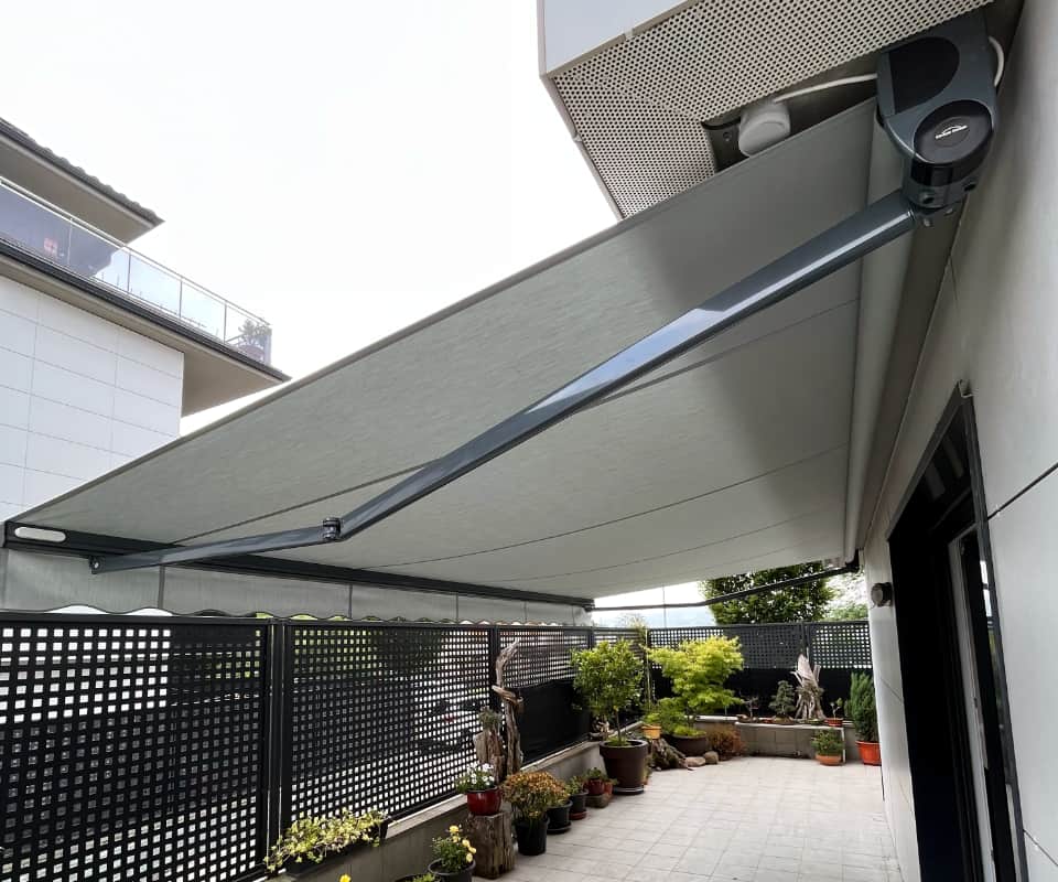 Toldo hedagarri grisa, landareak dituen terraza batean instalatua, Itzalki Toldoak enpresak Zarautzen (Gipuzkoa, Euskal Herria) egindakoa, Eibarren ere zerbitzua eskaintzen duena