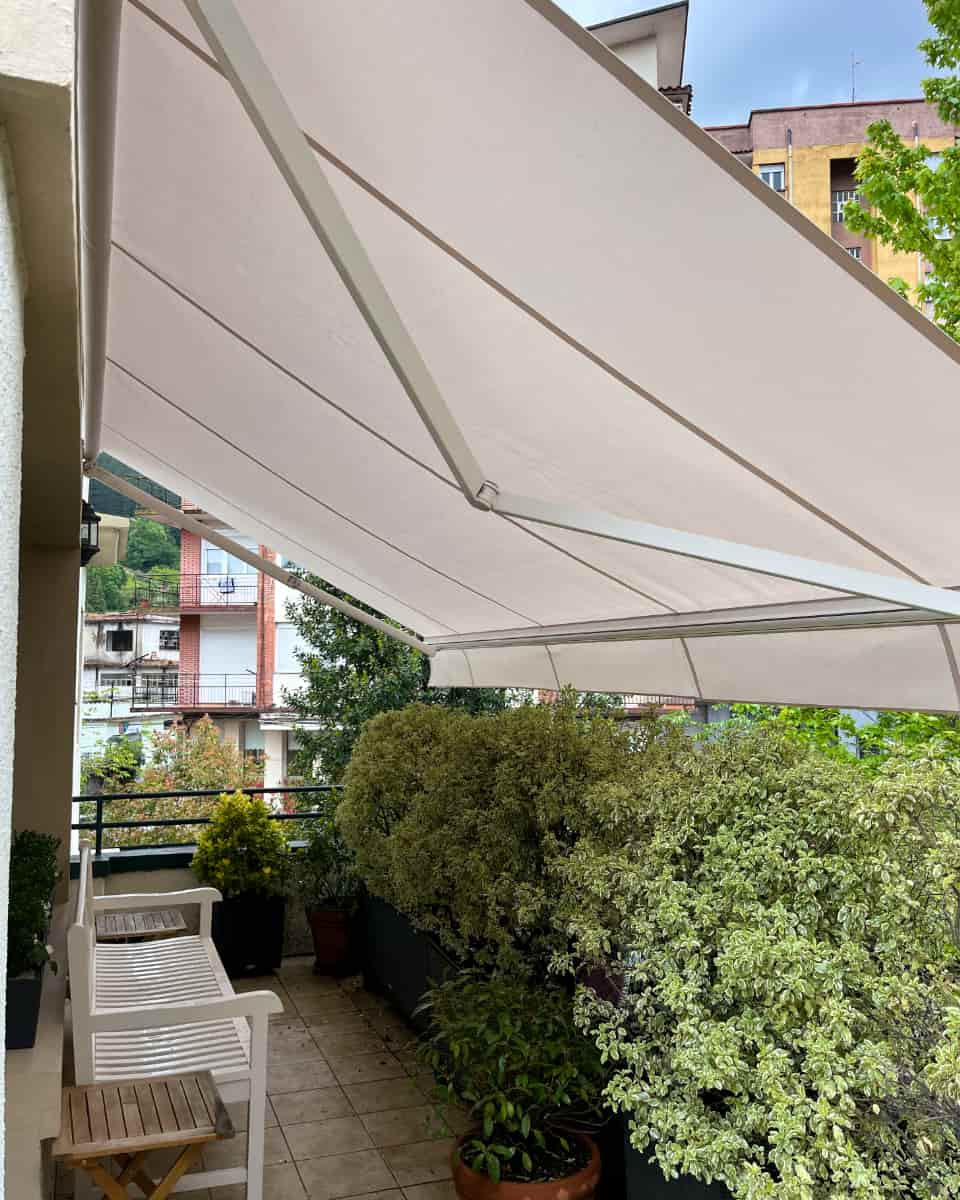 Toldo hedagarri zuria, landaredia duen terraza batean instalatua, Itzalki Toldoak enpresak Zarautzen (Gipuzkoa, Euskal Herria) egindakoa, Tolosan ere jarduten duena