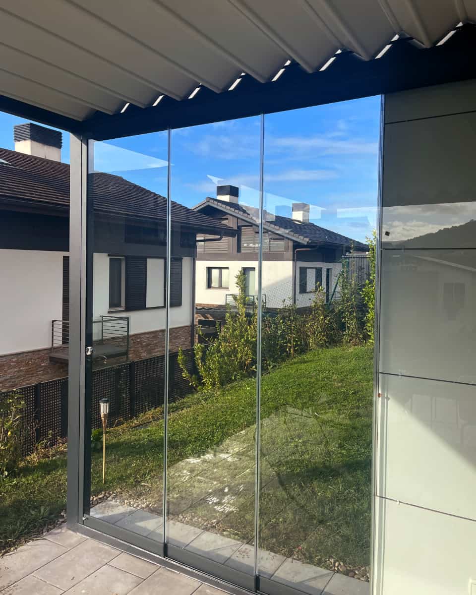 Egitura metalikozko terraza moderno batean instalatutako profilik gabeko alboko beirazko itxitura, Itzalki Toldoak enpresak Zarautzen (Gipuzkoa, Euskal Herria) egindakoa, Hondarribian ere zerbitzua eskaintzen du