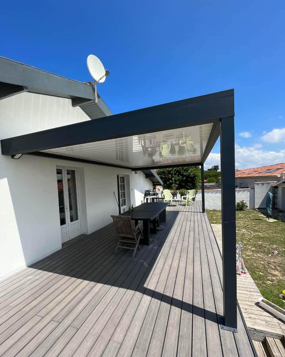 Pérgola bioclimática sobre terraza de madera con mesa de jardín instalada por Itzalki Toldoak, empresa en Zarautz, Guipúzcoa, País Vasco, con servicio también en Lasarte-Oria