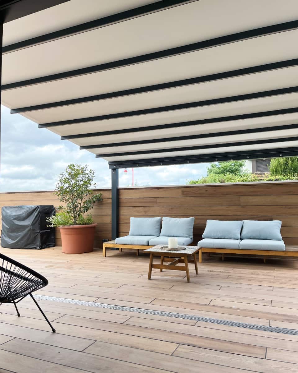 Pergola bioklimatikoa instalatua Itzalki Toldoak enpresak egurrezko zoruko terraza moderno batean Zarautzen (Gipuzkoa, Euskal Herria), Hernanin ere zerbitzua eskaintzen du