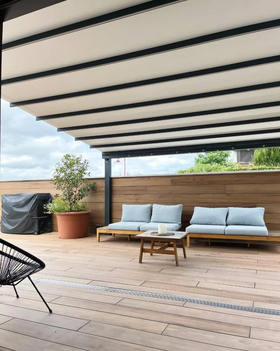 Pergola bioklimatikoa instalatua Itzalki Toldoak enpresak egurrezko zoruko terraza moderno batean Zarautzen (Gipuzkoa, Euskal Herria), Hernanin ere zerbitzua eskaintzen du