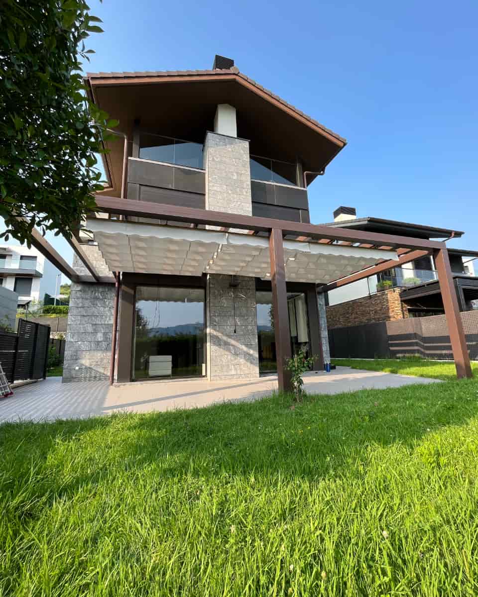 🖼 Texto alternativo (alt) Pérgola instalada con toldo textil tipo telón en jardín de vivienda unifamiliar por Itzalki Toldoak en Zarautz, Guipúzcoa, País Vasco, actuando también en Lasarte-Oria